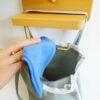 main qui dépose du papier toilette en tissu dans un sac