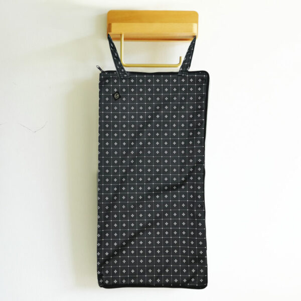 sac de stockage P'bag noir à petits carreaux de la marque Lafeuillet pour ranger le papier toilette lavable, suspendu sur mur blanc